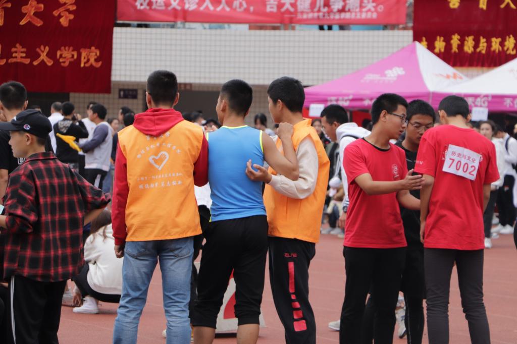 图为 公司志愿者搀扶比赛后的运动员(何小芳 摄)